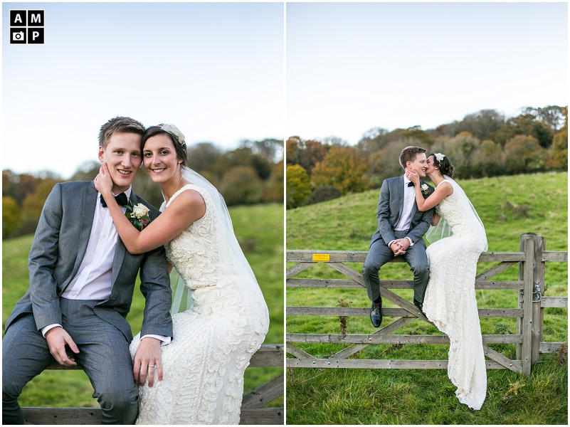"wedding-couple-sitting-on-a-wooden-fence-at-the-great-barn-devon"