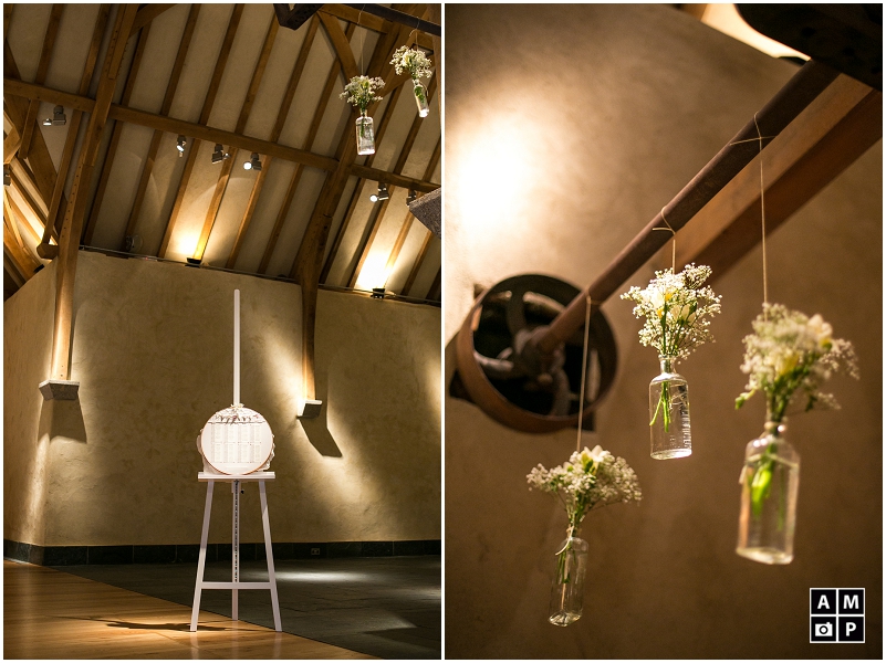 "hanging-glass-bottles-with-flowers-in-a-barn"