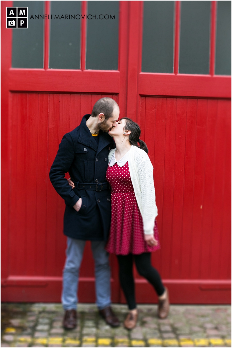 "Couple-kissing-in-front-of-a-red-door"