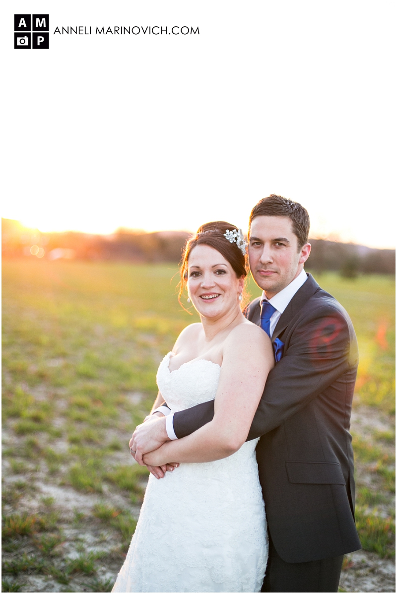 "bride-and-groom-in-a-field-at-sunset"