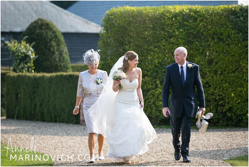 "bride-with-parents-walking-to-ceremony"