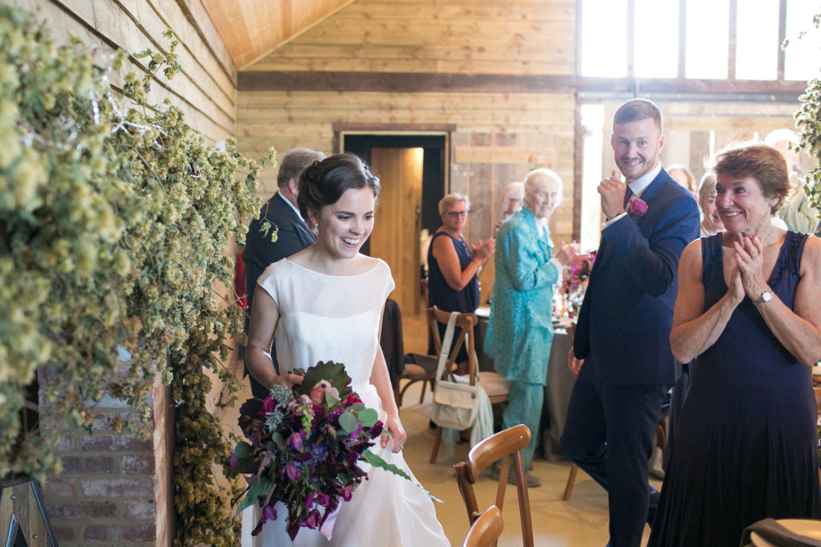 The bride and groom enters the barn at High Billinghurst Farm