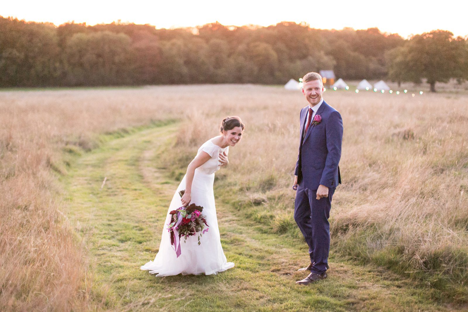 Bride and groom laughs at their dog running around at High Billinghurst Farm