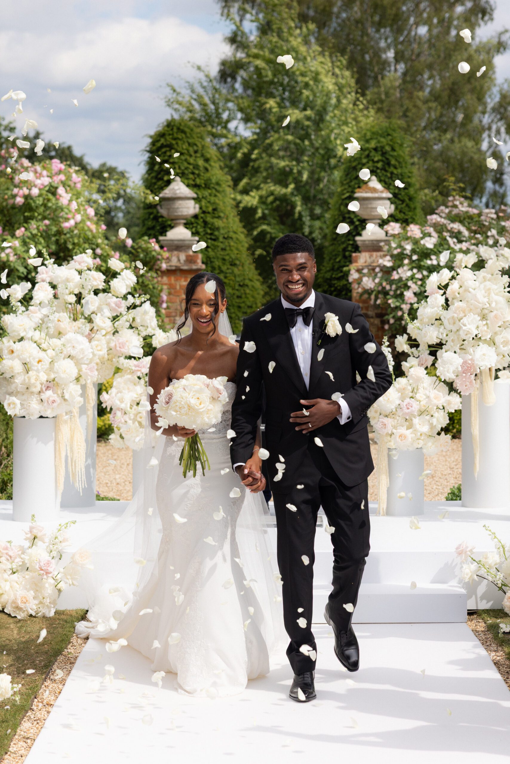 All-white confetti moment during an outdoor wedding ceremony