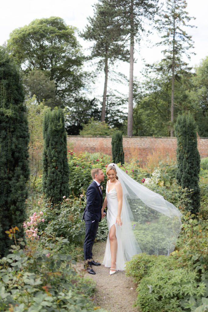 Middleton Lodge walled garden in bloom with a bride and groom sharing a romantic moment