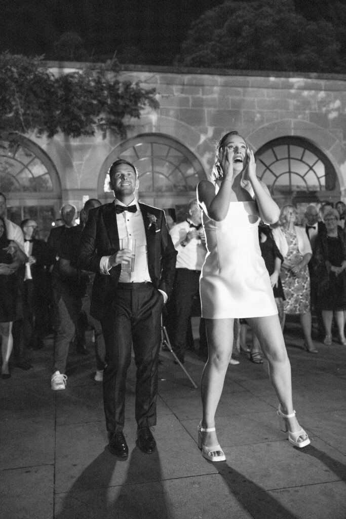 Emotional bride overcome with tears of joy while watching fireworks at her summer Middleton Lodge wedding